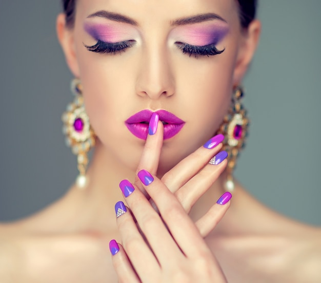 Stylish makeup in a purple hues,flawless black eyelashes and nicely shaped lips colored in violet.