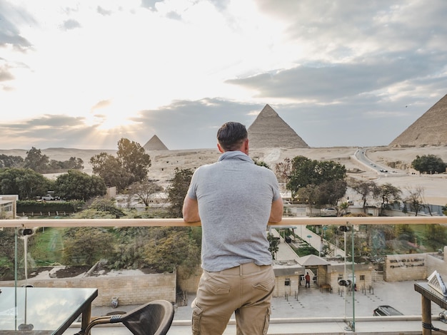 Stylish man against the background of the Giza pyramids
