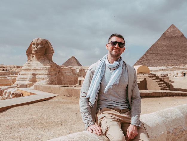 Stylish man against the background of the Giza pyramids