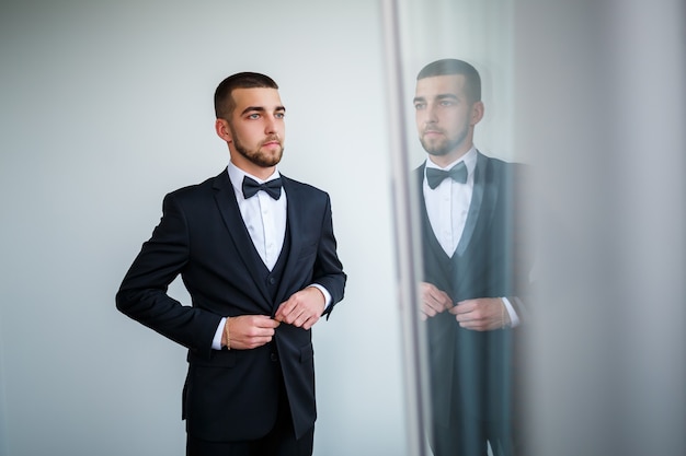 Stylish man businessman buttoning a button on a black jacket