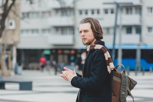 Photo stylish man in coat and scarf at city street of wroclaw poland