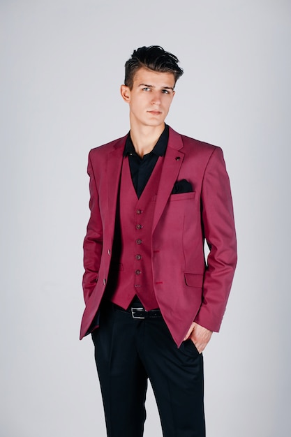 Stylish man in a crimson jacket on grey