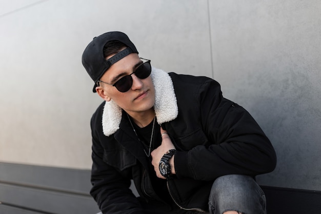 Stylish man in fashion jacket, cap and sunglasses