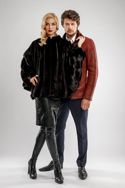 Stylish man and glamour woman in fur coat posing with Winter outfit.