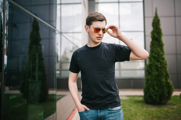 A stylish man in glasses and black T-shirt. Street photo