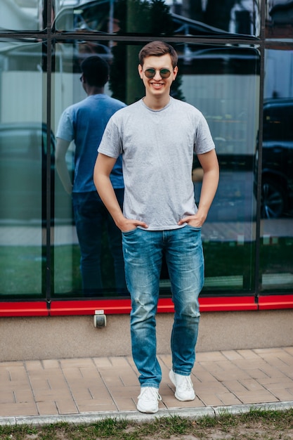 A stylish man in glasses and gray  T-shirt. Street photo