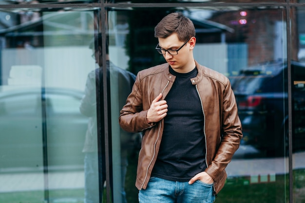 A stylish man in leather jacket, glasses and black T-shirt. Street photo