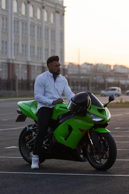 Stylish man on motorbike in evening