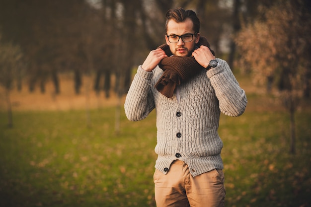 Stylish man posing in autumn park