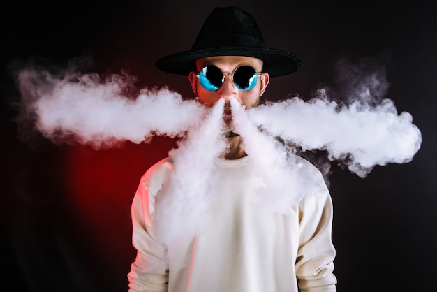 Stylish man puffing vapor