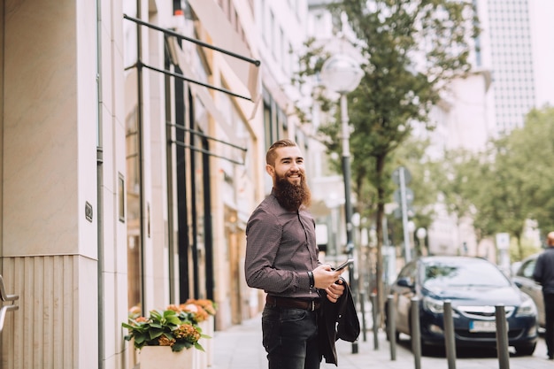 Stylish man with long beard with phone