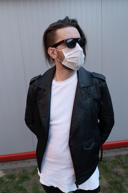 Stylish man with long hair in a protective mask