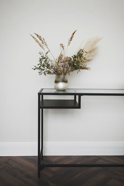 Stylish metal table with flowers in a light interior