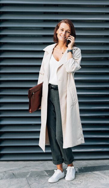 Stylish middleaged woman wearing a coat talking on a mobile phone