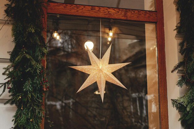 Premium Photo | Stylish modern christmas star hanging in window ...