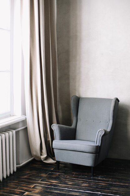 Stylish modern interior design with cozy armchair by the window.