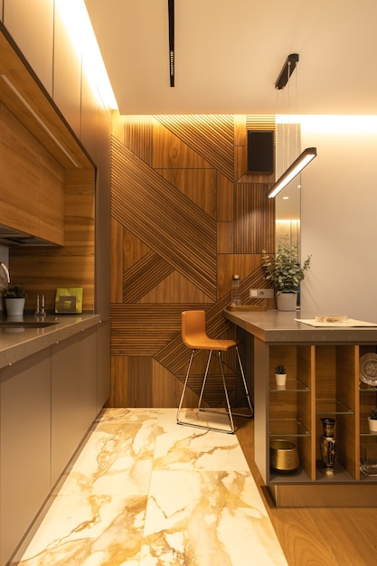 Photo stylish modern kitchen interior, details, studio. high bar stool, designer wood veneer panel on wall. concept minimal, fashionable interior, natural materials, wood, marble, metal. vertical.