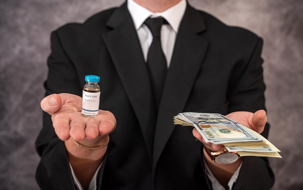 A stylish older man in a suit carries the vaccine in a jar and dollars for it