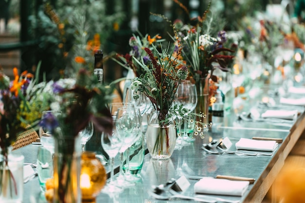 Stylish Outdoor Dinner Party. Decorated Table with beautiful wild flower bouquets