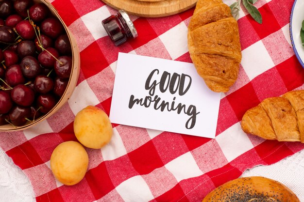 Stylish picnic  green lawn. fresh croissants and a teapot with tea on a bedspread near a wicker female hat. instagram content