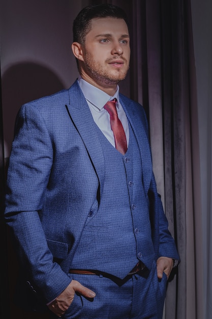 The stylish portrait of the groom preparing for the wedding ceremony in the morning. Morning of the groom. Morning preparation of the groom.