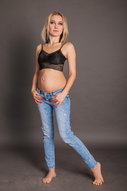 Фото Стильная беременная блондинка в джинсах современного материнства