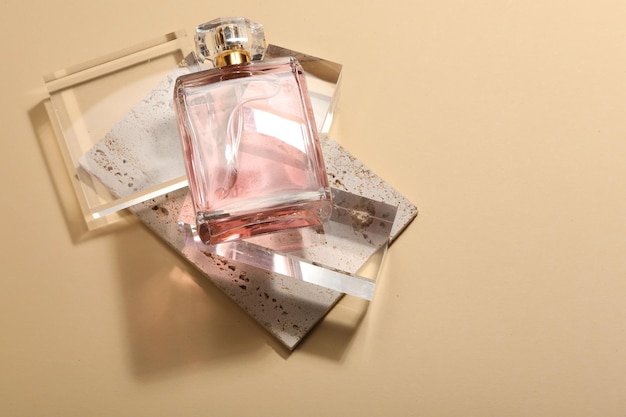 Stylish presentation of luxury womens perfume in sunlight on beige background above view Space for text