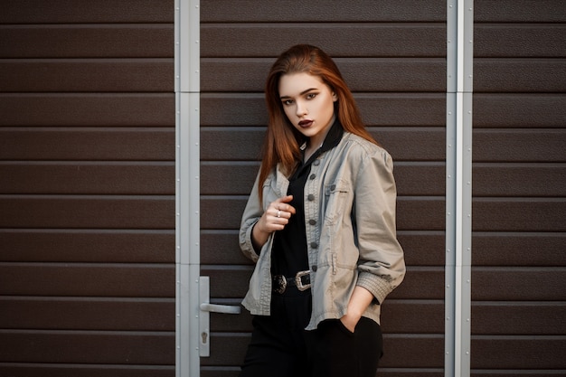 Stylish pretty young woman model in fashionable jacket and black polo shirt on the street