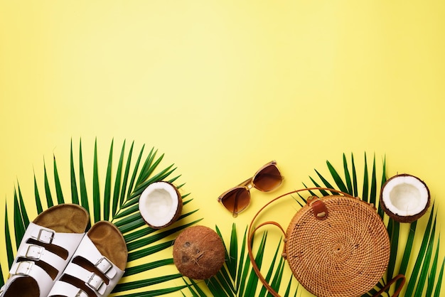 Фото Стильная сумка из ротанга кокосовые биркенстоки пальмовые ветви солнцезащитные очки на желтом фоне баннер вид сверху с копией пространства модная бамбуковая сумка и белые туфли летняя мода плоская планировка