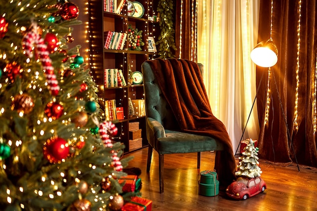 Stylish room interior with cozy armchair and beautiful christmas tree in evening cozy house