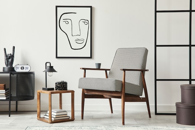 Stylish scandinavian composition of living room with design armchair, black frame, commode, wooden stool, book, decoration, loft wall and personal accessories in modern home decor.