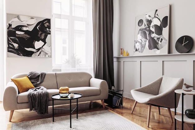 Elegante interni scandinavi del soggiorno con divano grigio design poltrona sgabello in marmo tavolino nero dipinti moderni decorazione piante ed eleganti accessori personali nell'arredamento della casa