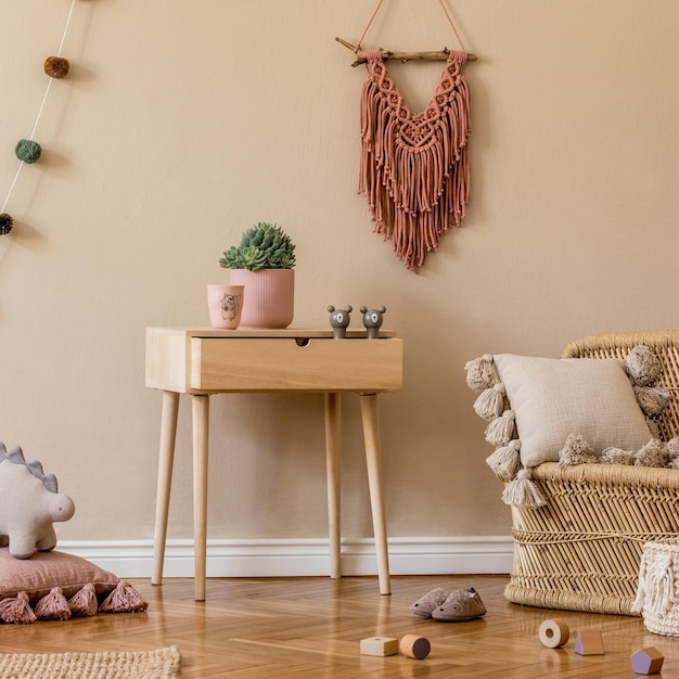 Stylish scandinavian interior of child room with natural toys, hanging decoration, design furniture, plush animals, teddy bears and accessories. Beige walls. Interior design of kid room. Template.