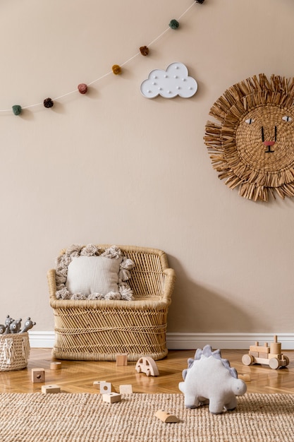 천연 장난감, 매달린 장식, 디자인 가구, 봉제 동물, 테디 베어 및 액세서리가있는 어린이 방의 세련된 스칸디나비아 인테리어. 베이지 색 벽. 아이 방의 인테리어 디자인. .