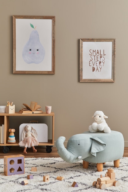 Stylish scandinavian kid room interior with toys, teddy bear, plush animal toys, furniture, decoration and child accessories. Brown wooden frames on the wall.