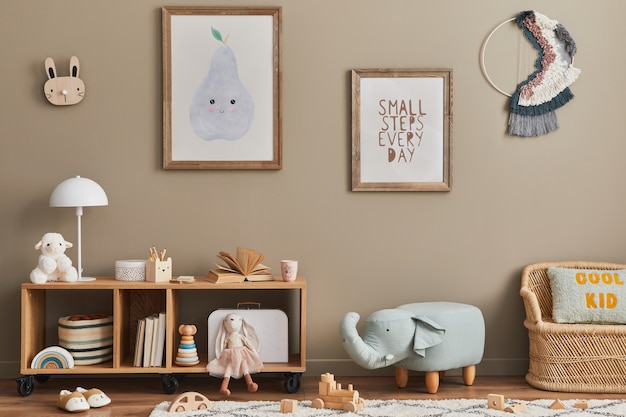 Stylish scandinavian kid room interior with toys, teddy bear, plush animal toys, mint armchair, furniture, decoration and child accessories. Brown wooden frames on the wall. Template