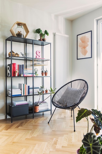 Stylish scandinavian living room with design armchair and bookstand with accessories