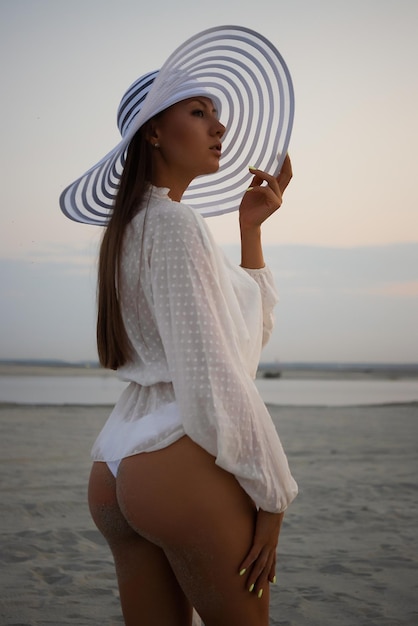 Stylish sensual woman in beachwear and hat