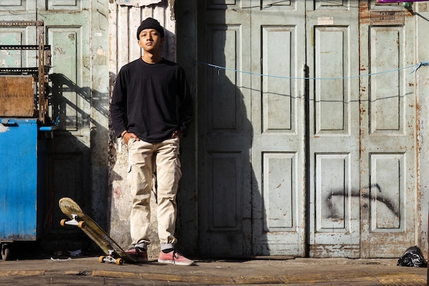 Photo stylish skateboarder in street with casual clothes posing to camera