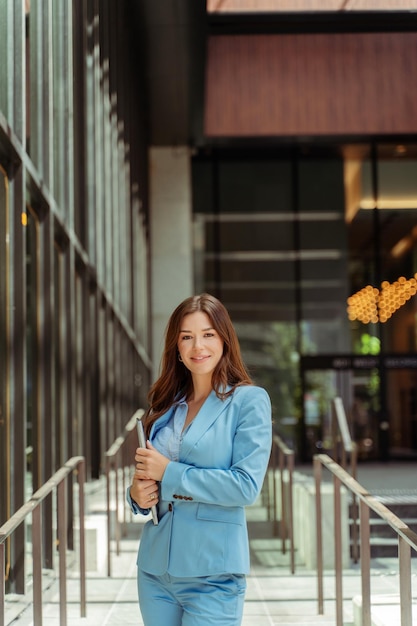 Stylish smart businesswoman wearing formal wear holding laptop looking at camera