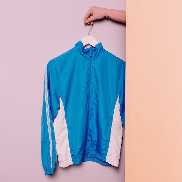 Photo stylish sportswear. minimal fashion. blue jacket on a hanger. wardrobe trends