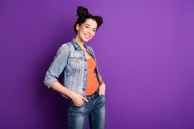 Stylish student with curly hair posing against the purple wall