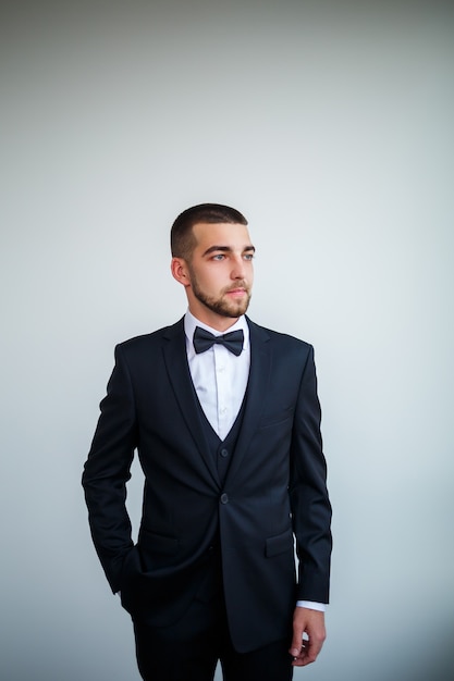 Stylish successful male businessman in a black jacket and with a bow tie