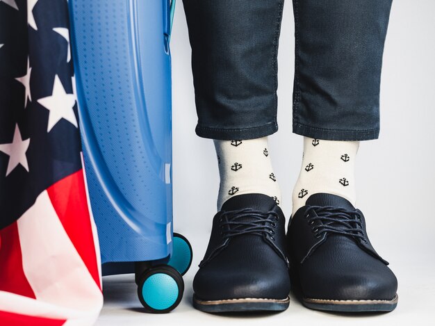 Stylish suitcase, US Flag, men's legs and bright socks