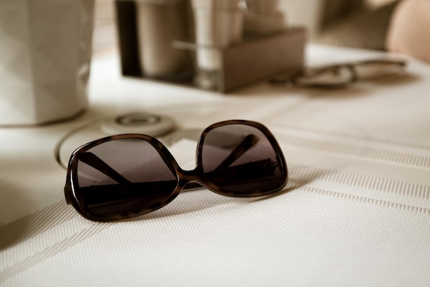 Stylish sunglasses lying on table