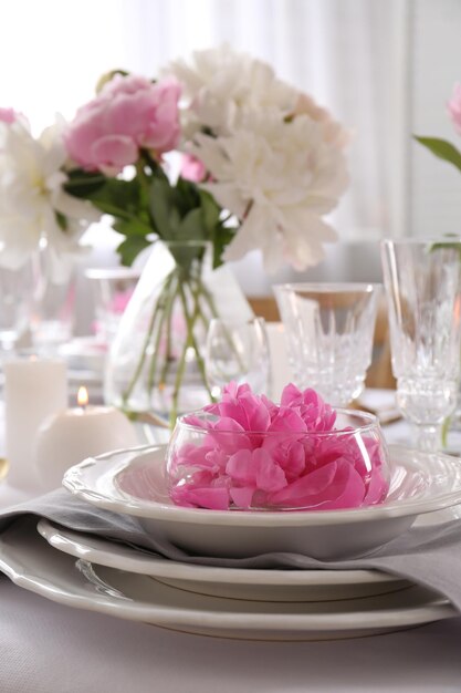 Foto elegante tavolo apparecchiato con bellissime peonie nella sala da pranzo in primo piano spazio per il testo