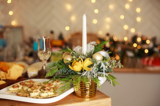 Stylish table setting with burning candles and Christmas decorations. Luxury romantic candlelight dinner table setup for couple. Wine glasses and beautiful food decoration. Romantic fine dining