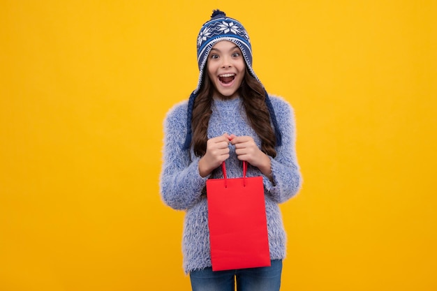 Stylish teen girl in winter warm hat with shopping sale bags
kid holding purchases happy face positive and smiling emotions of
teenager girl