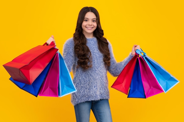 Stylish teen girl with shopping sale bags Kid holding purchases Happy teenager positive and smiling emotions of teen girl