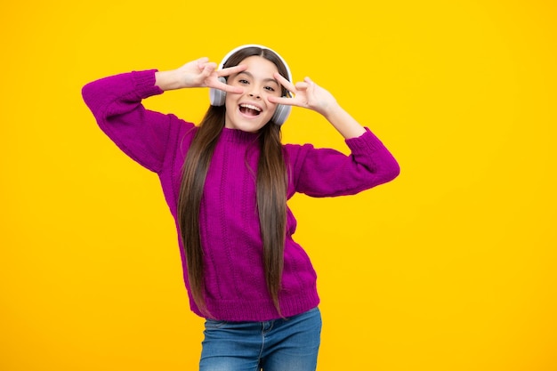 Stylish teenage girl listening to music with headphones Kids lifestyle concept Wireless earphones Excited face Amazed expression cheerful and glad